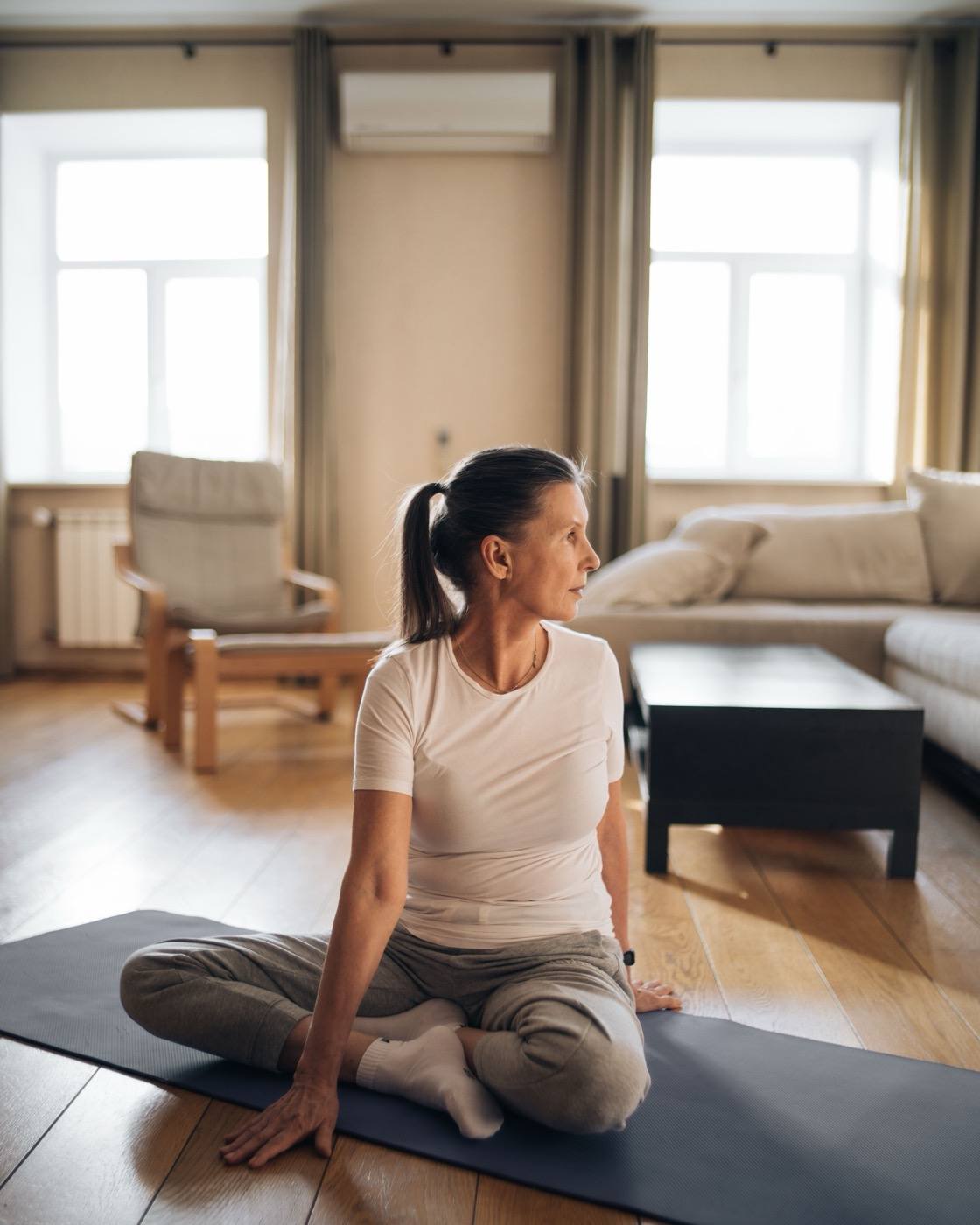 A woman sitting on the floor at home in morning light